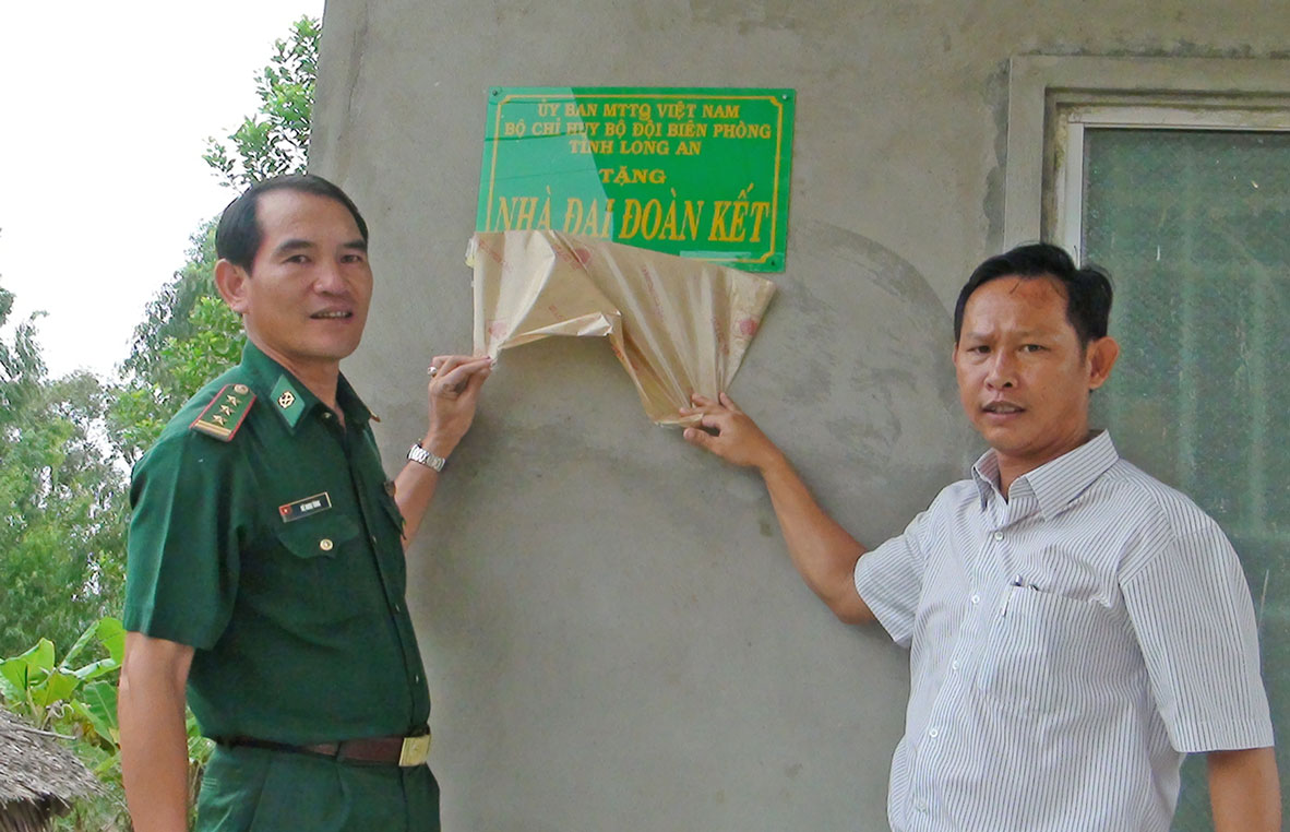 Thượng tá Vũ Minh Tùng - Phó Chủ nhiệm chính trị, Bộ đội Biên phòng tỉnh, đại diện UBMTTQ Việt Nam thị xã Kiến Tường trao nhà Đại đoàn kết cho gia đình anh Nguyễn Thanh Phong 