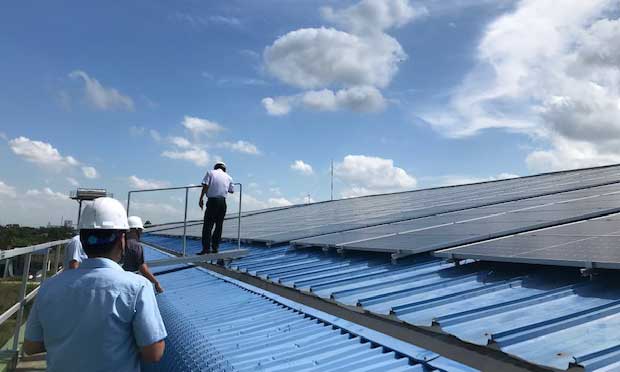 Nhân viên lắp đặt tấm pin năng lượng điện mặt trời trên mái nhà 