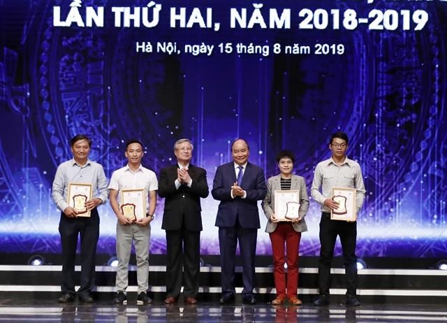 PM highlights press’s role in fighting corruption Prime Minister Nguyen Xuan Phuc (third from right) and the winners of press awards for the fight against corruption and wastefulness."(Photo: VNA)
