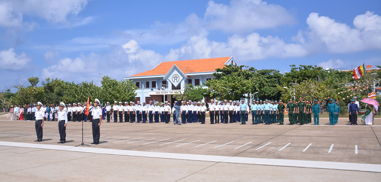 Các thành viên trong đoàn công tác cùng quân, dân đảo Trường Sa tham gia lễ chào cờ tại đảo
