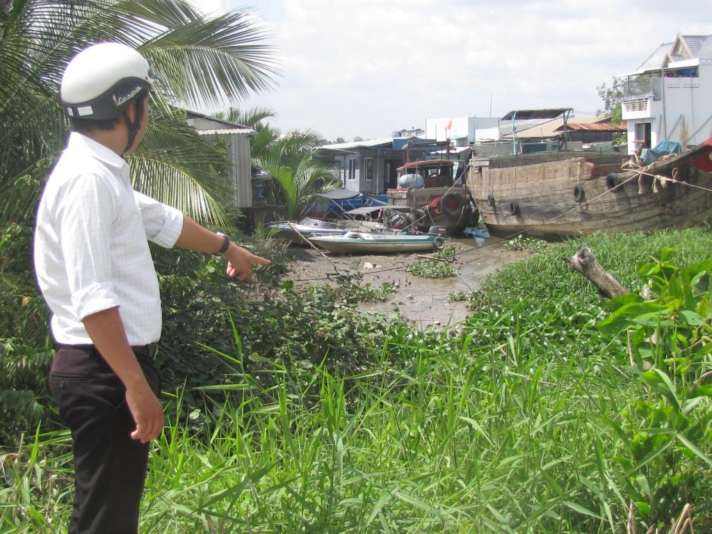 Cán bộ địa chính –giao thông thủy lợi xã Tân Chánh –Nguyễn Hoàng Vũ chỉ tay vào khu vực chuẩn bị xây mới cống Bà Nghĩa, ấp Bà Nghĩa, xã Tân Chánh giáp với sông Vàm Cỏ.