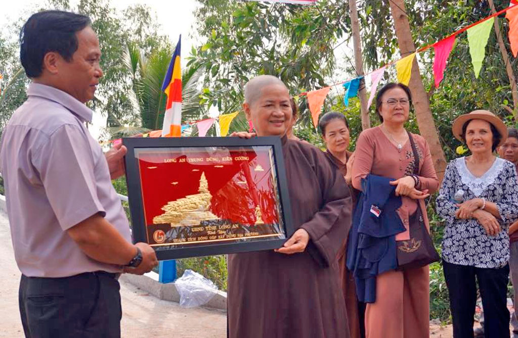 Inauguration of Go Co Do Bridge Deputy Secretary of Party Committee of Tan Thanh commune - Ho Phuoc Hung awarded certificates of merit and souvenirs of Long An provincial People's Committee to the representative of Bao Quang Pagoda