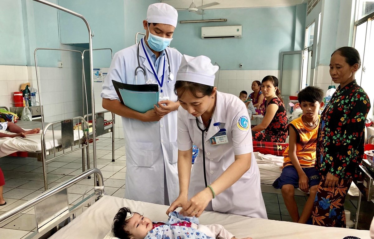 Các bác sĩ Bệnh viện Sản nhi An Giang thăm khám cho một bệnh nhi mắc sốt xuất huyết. (Ảnh: Thanh Sang/TTXVN)