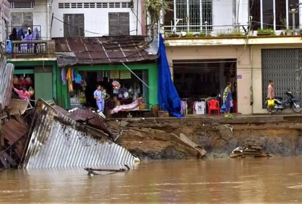 Nhà dân bị nhấn chìm xuống sông Rạch Vọp. (Ảnh: Trung Hiếu/TTXVN)