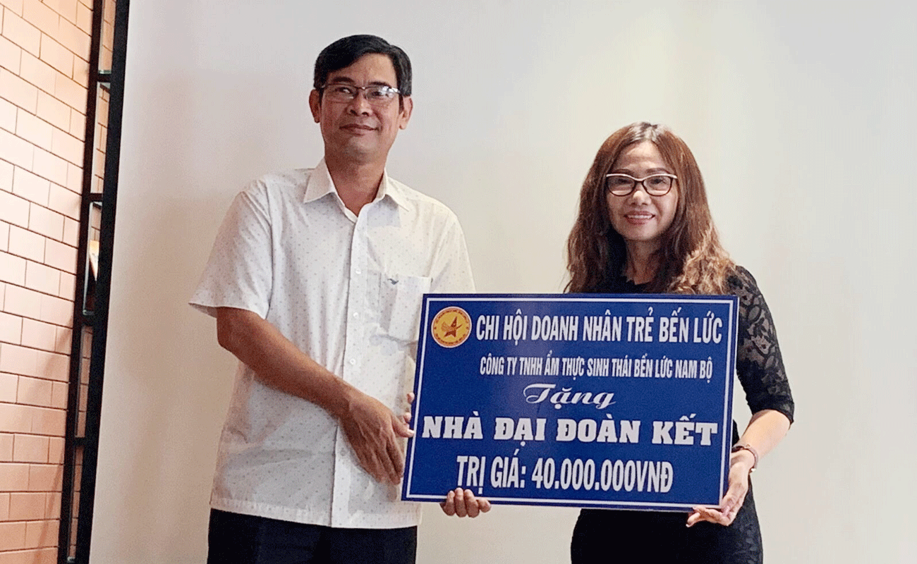 Giám đốc Cty TNHH ẩm thực sinh thái Bến Lức Nam bộ - Nguyễn Thi Thu Hương trao bảng tượng trưng nhà Đại đoàn kết
