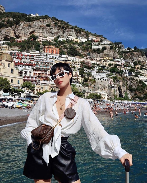 Chiếc túi 3 trong 1 của Louis Vuitton trở thành bảo bối theo chân Khánh Linh đi khắp châu Âu, Tại điểm dừng chân ở Positano (Italy), cô nàng mix túi cùng sơ mi buộc vạt với quần shorts, vừa cá tính vừa sang chảnh.