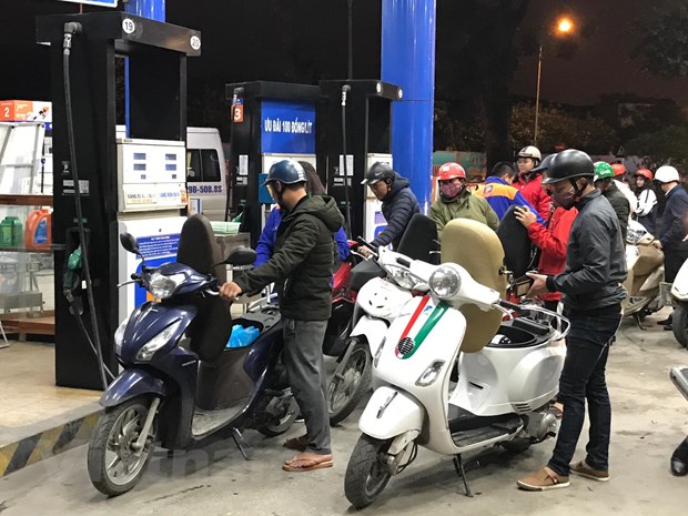 Nhân viên Petrolimex đang bán xăng cho khách hàng. (Ảnh: Đức Duy/Vietnam+)