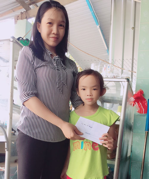 Chị Lại Thị Kim Minh hỗ trợ tiền cho bé Châu Phương Thảo