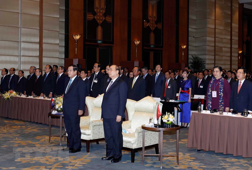 Thủ tướng Nguyễn Xuân Phúc và Thủ tướng Vương quốc Campuchia Samdech Techo Hun Sen xem một số hình ảnh trưng bày tại Hội nghị. (Ảnh: Thống Nhất/TTXVN)