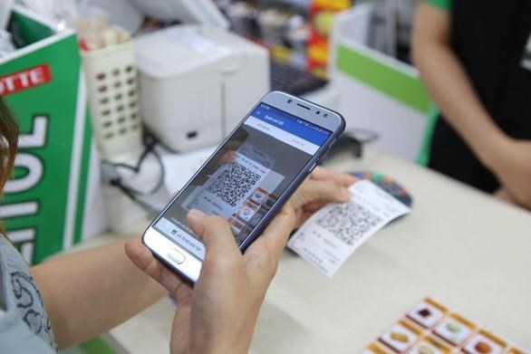Conference to seek measures for Vietnam’s fintech development A customer makes payment by QR code at a supermarket (Photo: VNA)