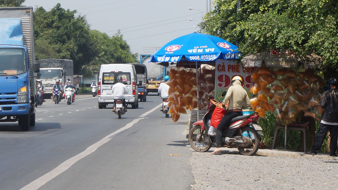 Dựng ô, dù buôn bán lấn chiếm hành lang đường bộ còn làm gia tăng nguy cơ tai nạn giao thông