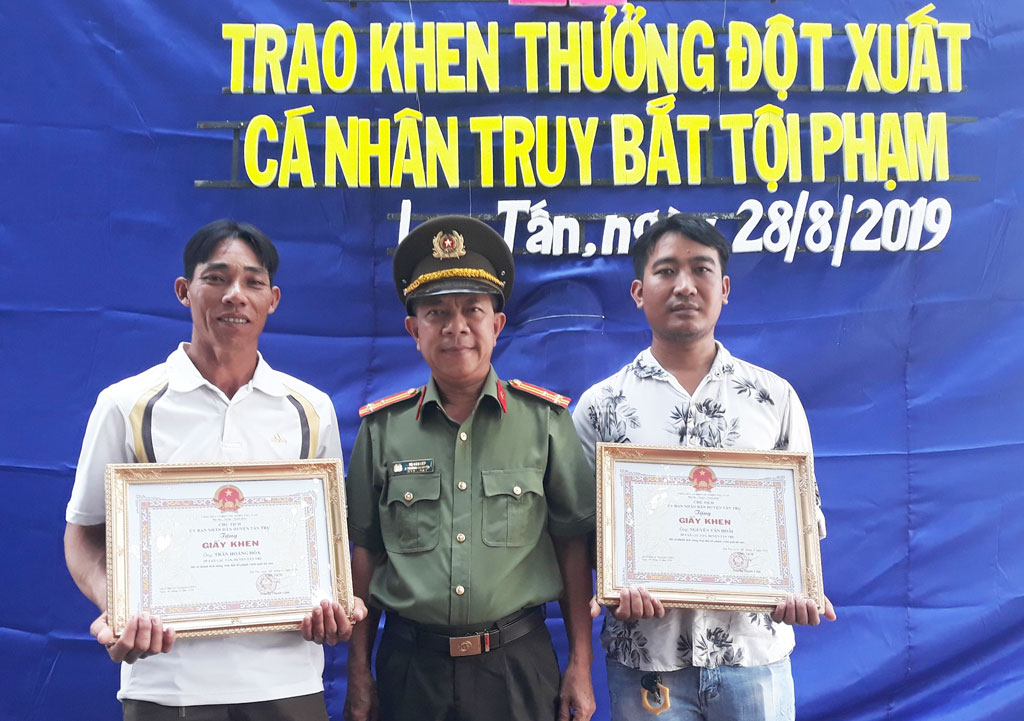 Thượng tá Võ Văn Liếp - Phó Trưởng Công an huyện Tân Trụ, trao giấy khen của Chủ tịch UBND huyện cho các cá nhân có thành tích trong  truy bắt tội phạm Ảnh: HồNG THÁI