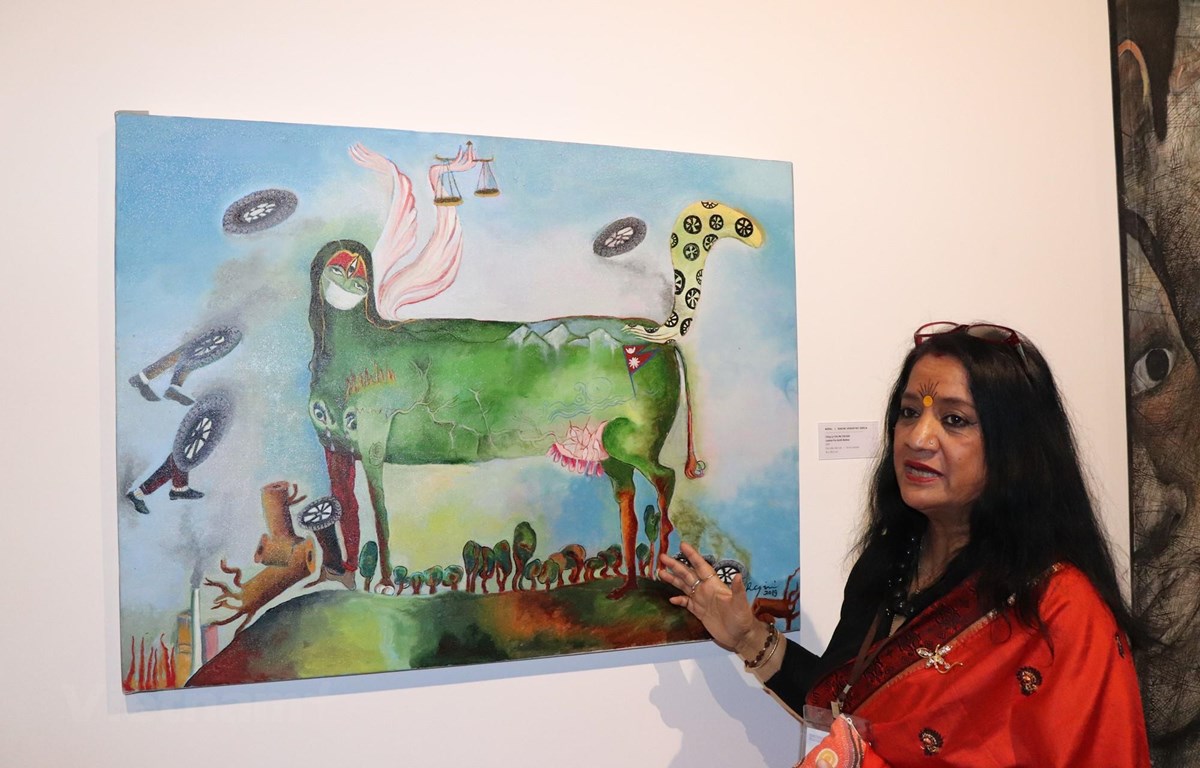 Nữ nghệ sỹ Ragini bên tác phẩm Justice for Nature (Công lý cho tự nhiên), với thiên nhiên được nhân cách hóa trong hình tượng Mẹ Trái Đất. (Ảnh: Linh Trang/Vietnam+)