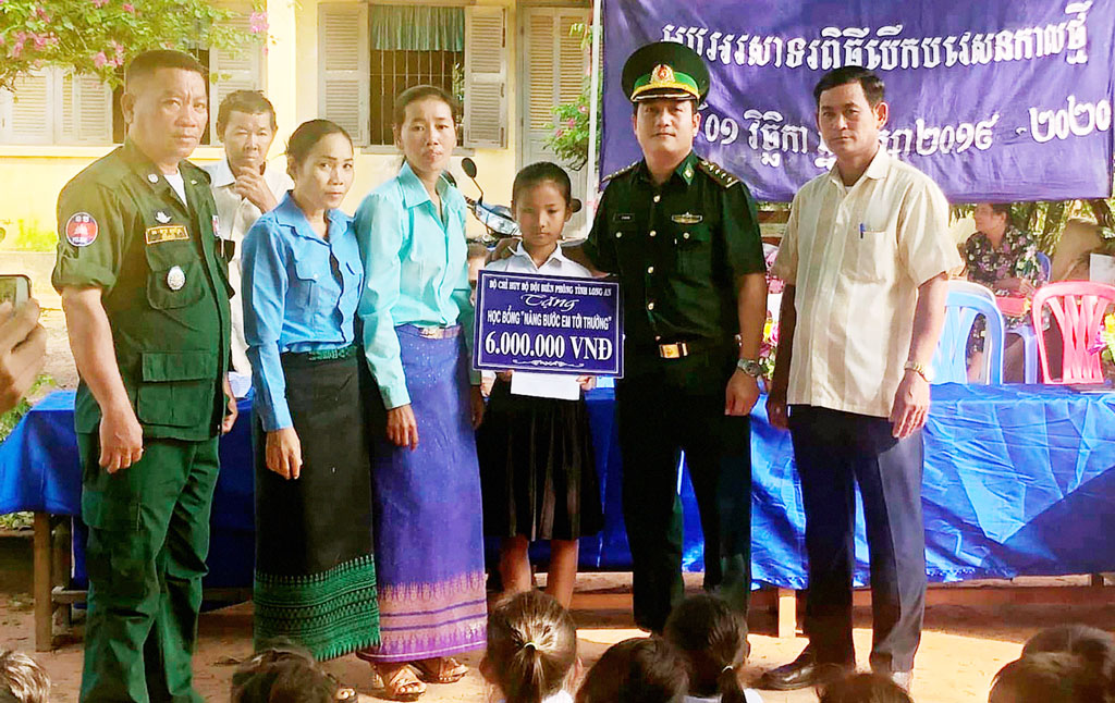 Đại úy Lê Trung Sơn - Chính trị viên phó Đồn Biên phòng Thạnh Trị, trao học bổng "Nâng bước em tới trường" cho em Phan Chan Tria Try