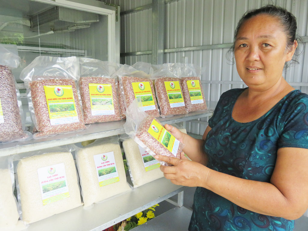 Bà Nguyễn Thị Diệu Ngân giới thiệu các loại gạo đang bán tại điểm bán của hợp tác xã