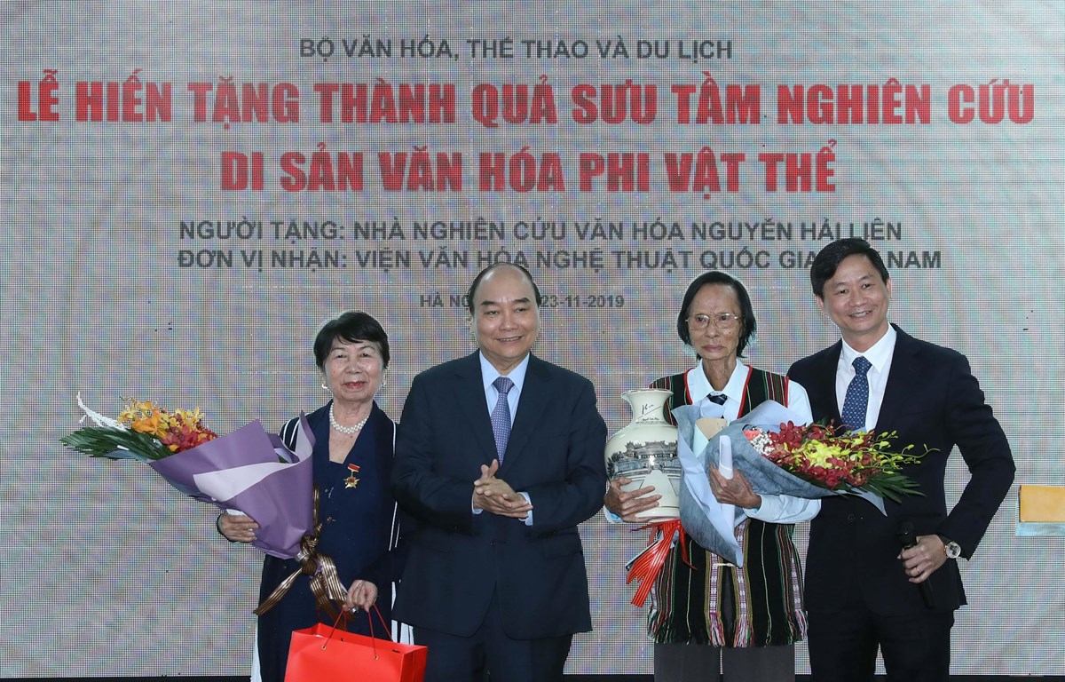 'Phải biến văn hóa trở thành di sản và tạo sinh kế cho người dân' Thủ tướng Nguyễn Xuân Phúc tặng hoa Nhà nghiên cứu văn hoá Nguyễn Hải Liên. (Ảnh: Thống Nhất /TXVN)
