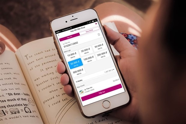 Central bank to lower foreign ownership in payment intermediaries A person uses the MoMo e-wallet. As of November this year, Vientam had 30 payment intermediary service providers licensed by the State Bank. (Photo: momo.vn)