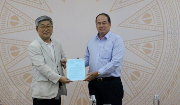 Chủ tịch Ủy ban Nhân dân tỉnh An Giang Nguyễn Thanh Bình (bên phải) trao chứng nhận cho ông Oh Se-young, người đại diện Khu công nghiệp Smat Hàn Quốc. (Ảnh: Công Mạo/TTXVN)