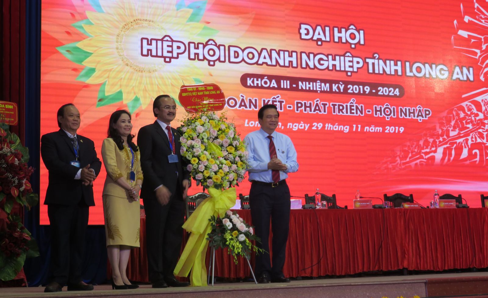Long An: Mr. Vo Quoc Thang re-elected Chairman of Long An Business Association for course III, term 2019 - 2024 Secretary of the Provincial Party Committee, Chairman of the Provincial People's Council - Pham Van Ranh (R) presents flowers to congratulate the Congress