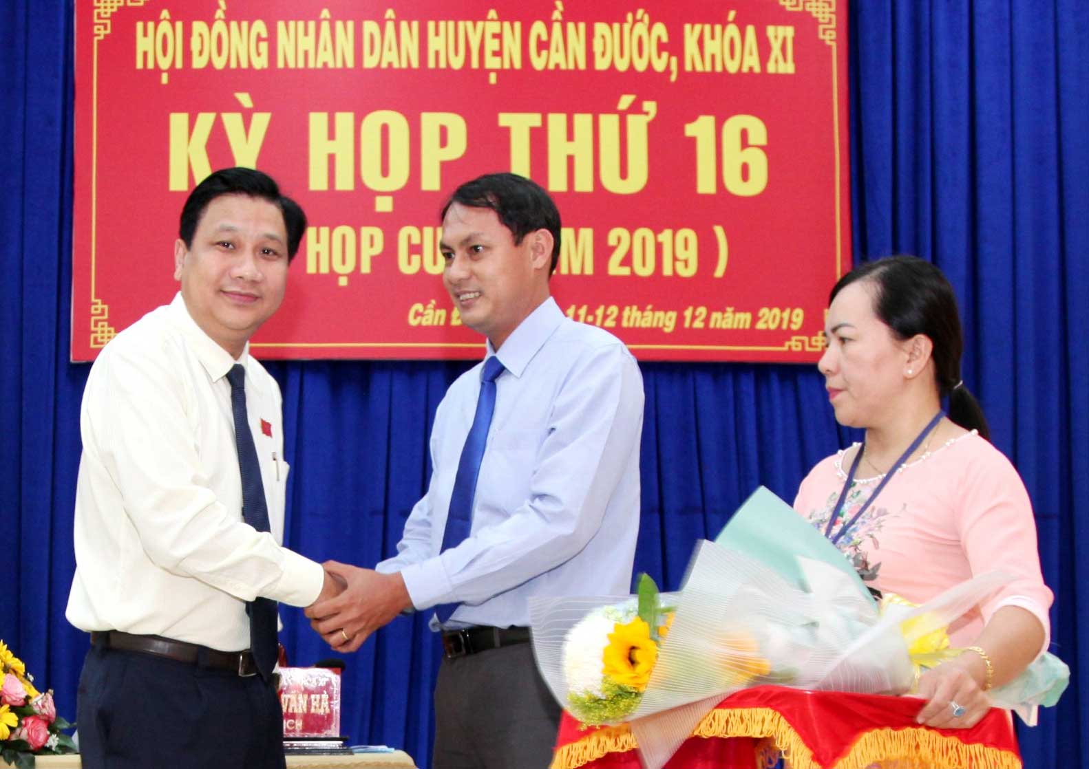 Bí thư Huyện ủy, Chủ tịch HĐND huyện Nguyễn Việt Cường tặng hoa chúc mừng ông Đào Hữu Tấn 