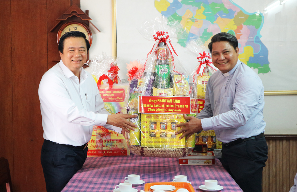 Secretary of the Provincial Party Committee, Chairman of Long An Provincial People's Council - Pham Van Ranh (L) presents Christmas greetings to Father Nguyen Van Nhan - Priest of Tan An Parish