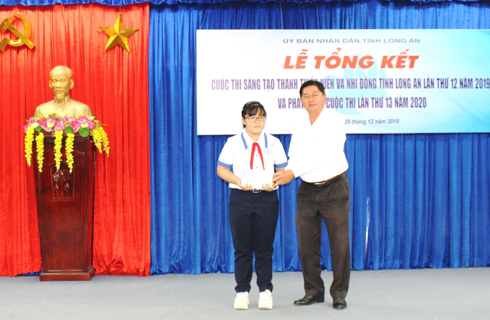 Vice Chairman of the provincial Vietnam Association for Promotion of Studies - Vo Le Tuan presents gifts to Le Thanh Truc – a student of Hau Nghia Secondary School