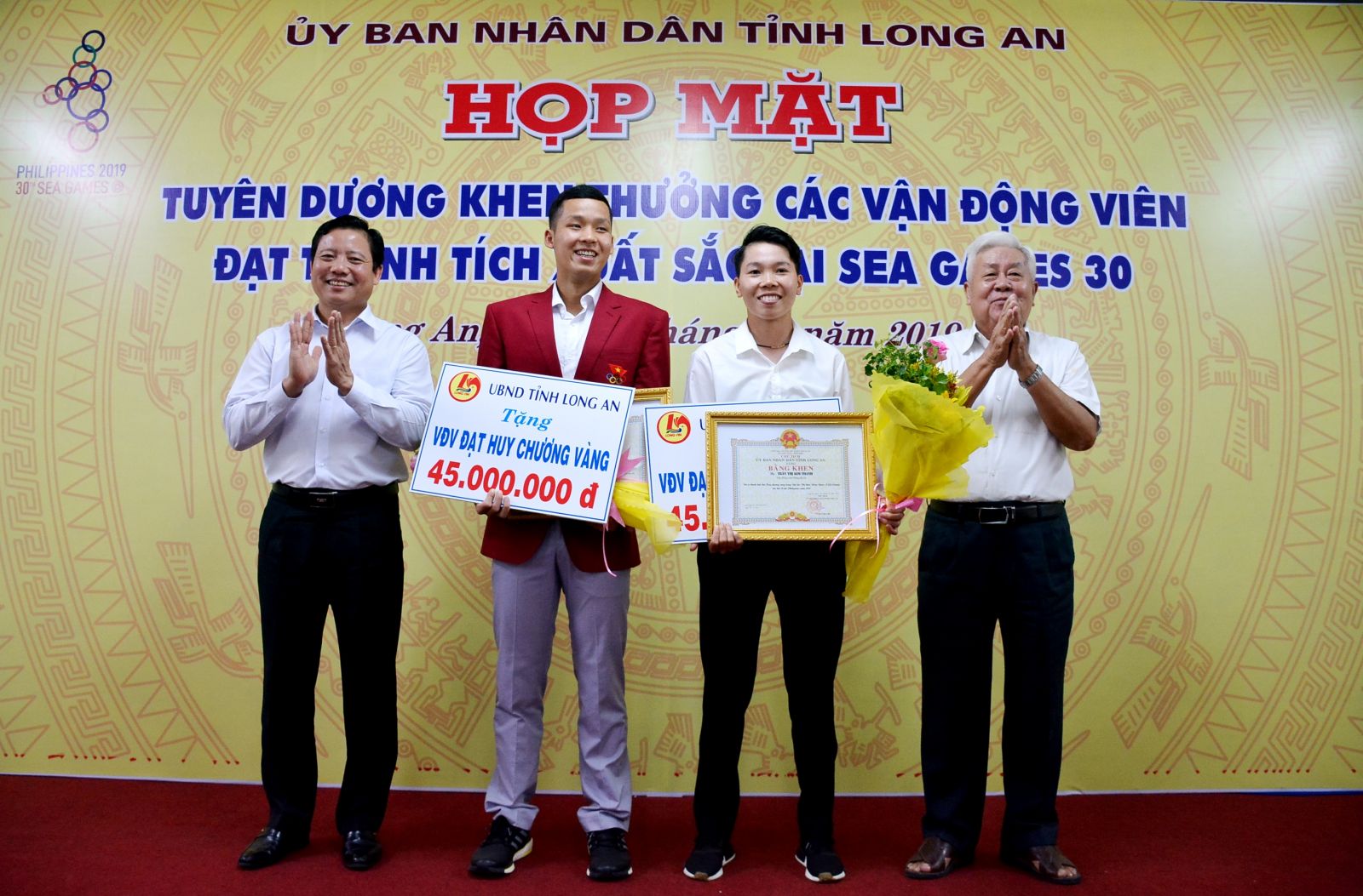 Former Secretary of the Provincial Party Committee - Le Thanh Tam (R) and Vice Chairman of the Provincial People's Committee - Pham Tan Hoa presented certificates of merit and bonuses to 2 Long An athletes winning gold medals at SEA Games 30