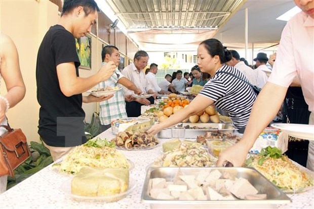 Vietnamese people enjoy traditional foods to welcome the New Year at the Vietnamese Embassy in Angola. (Photo: VNA)