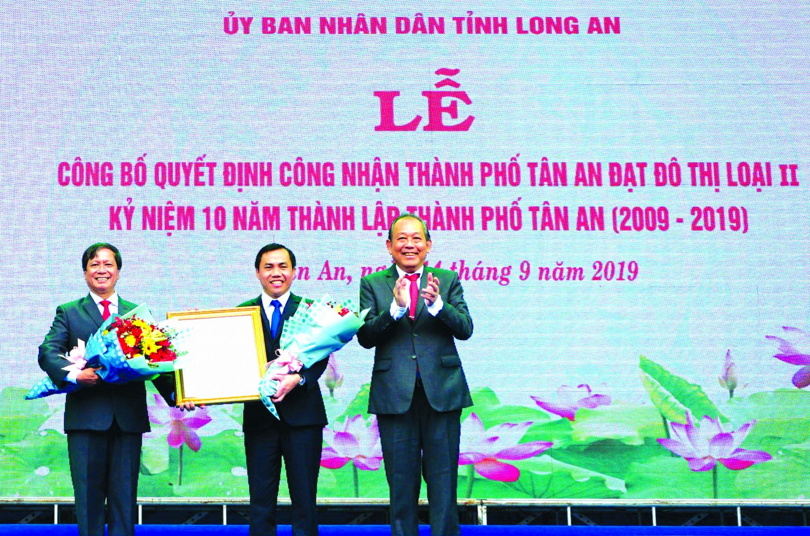 Under the authorization of the Prime Minister, the Standing Deputy Prime Minister - Truong Hoa Binh awards the Decision on recognizing Tan An city as a type-II city to city leaders.