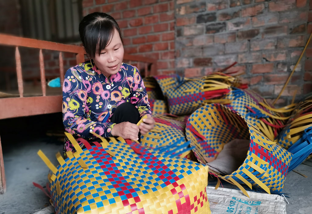 Chị Lê Thị Kiều Chinh đan giỏ nhựa để tăng thêm thu nhập lúc nông nhàn
