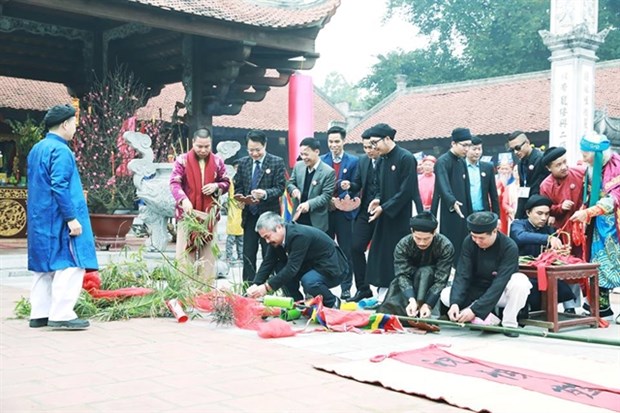 People erect a 'cay neu' (symbolic bamboo tree) at the Tet Viet event in 2018 in the Communal House in Le Mat Village in Long Bien District, Hanoi. (Photo: VNA)