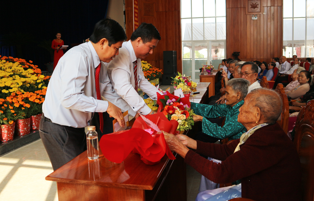 Secretary of the District Party Committee, Chairman of the District People's Council - Nguyen Van Dat (L) and Chairman of the District People's Committee - Lam Hoa Xung gives flowers to the Hero Vietnamese Mother