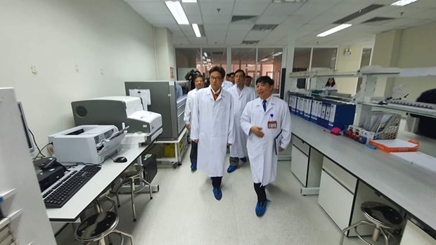 Phó Thủ tướng Vũ Đức Đam kiểm tra phòng thí nghiệm của Bệnh viện Bệnh Nhiệt đới Trung ương. (Ảnh: PV/Vietnam+)