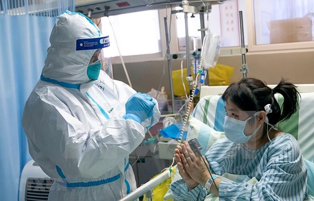 A medical worker treats a coronavirus patient at Wuhan hospital in Hubei province, China. (Photo: Xinhua/VNA)