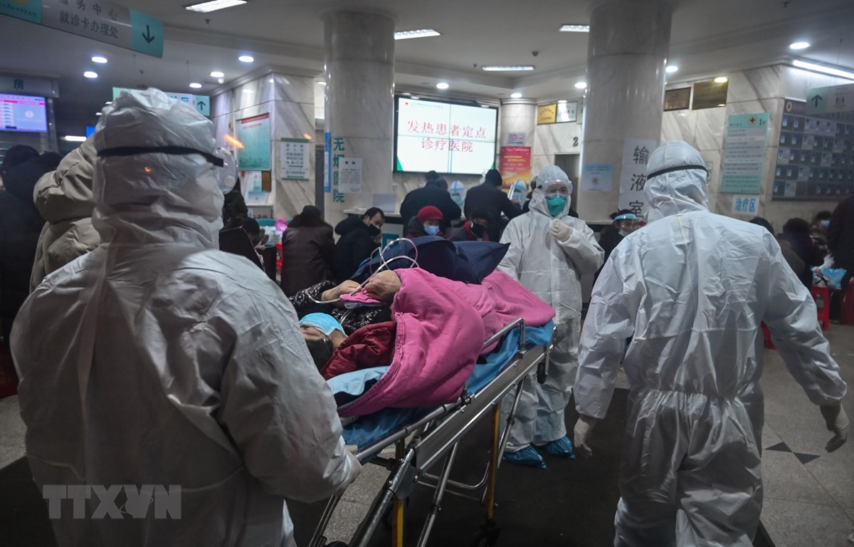 Nhân viên y tế chuyển bệnh nhân nhiễm virus corona mới gây bệnh viêm phổi tới bệnh viện ở Vũ Hán, tỉnh Hồ Bắc, Trung Quốc. (Ảnh: AFP/TTXVN)