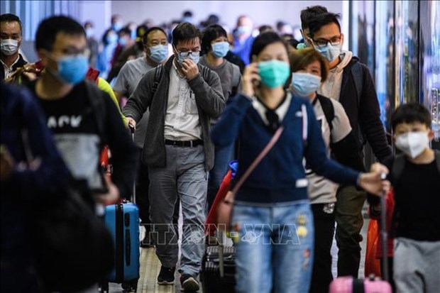 Passengers wear masks at a train station to prevent the nCoV spread (Photo: AFP/VNA)