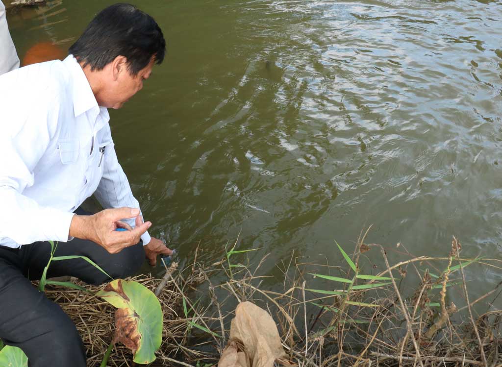 Phó Giám đốc  Sở Nông nghiệp và Phát triển nông thôn - Nguyễn Chí Thiện trực tiếp lấy mẫu nước để kiểm tra độ mặn, hướng dẫn các địa phương lấy để bơm nước dự trữ