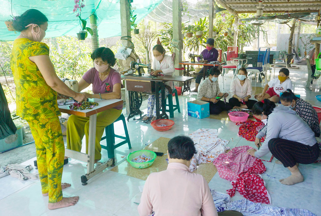 Bà Võ Thị Kiều Oanh (ngồi may đầu tiên, bên trái) cùng các hội viên, cắt, may khẩu trang sau một ngày làm việc