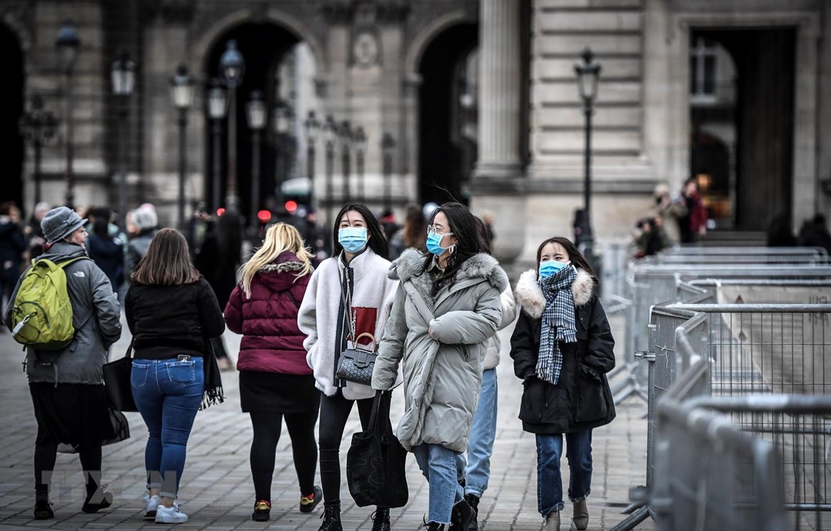 Người dân và du khách đeo khẩu trang phòng tránh lây nhiễm COVID-19 tại Paris, Pháp. (Ảnh: AFP/TTXVN)