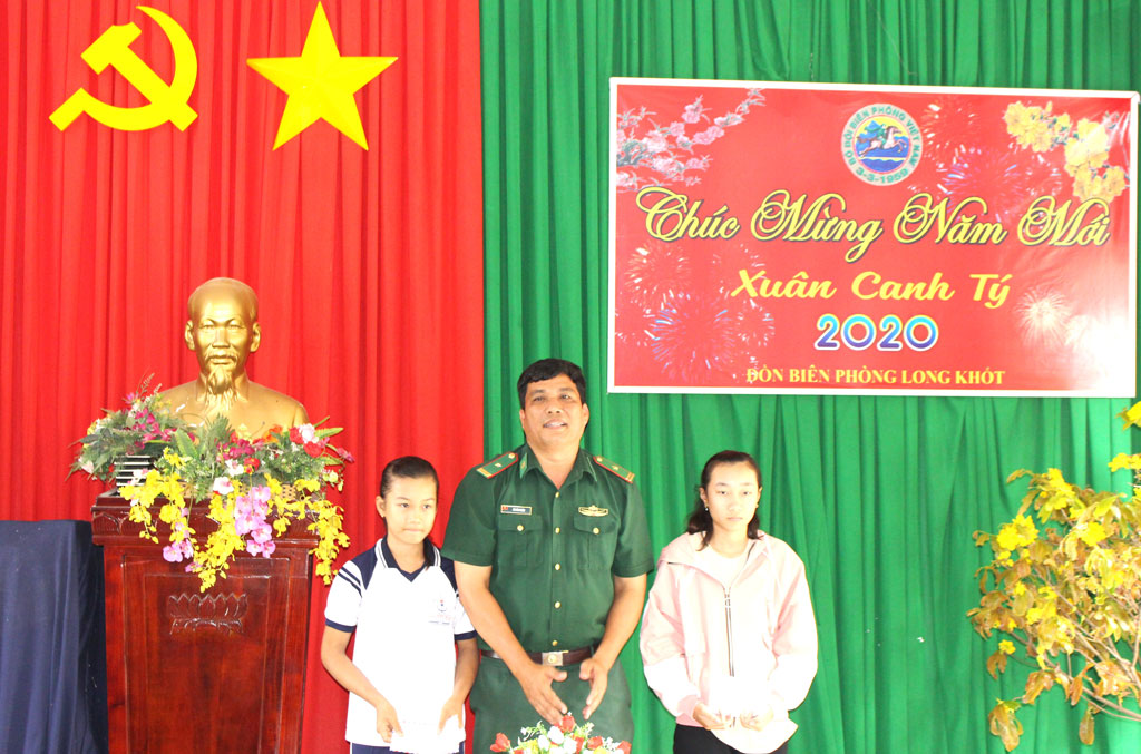 Đồn trưởng Đồn Biên phòng Long Khốt - Bùi Văn Thuận trao tiền hỗ trợ cho các em học sinh nhận đỡ đầu từ chương trình “Nâng bước em tới trường”