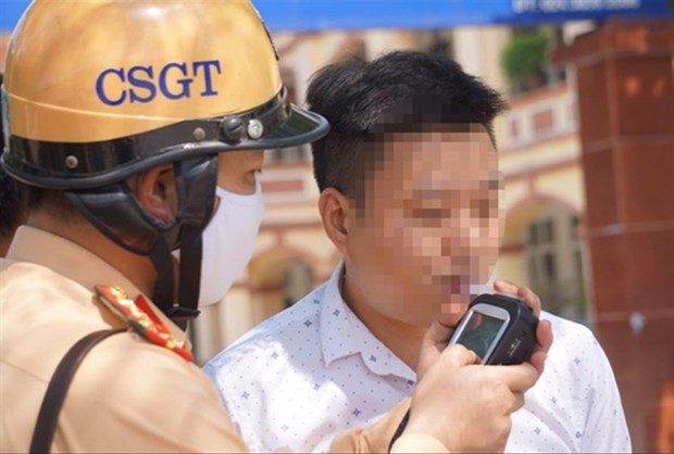 Police breathalyze a driver on Hanoi's Xuan La street. (Photo: tienphong.vn)
