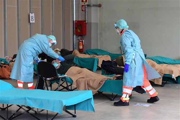 Nhân viên y tế điều trị cho bệnh nhân mắc COVID-19 tại một bệnh viện dã chiến ở Lombardy, Italy. (Ảnh: AFP/TTXVN)