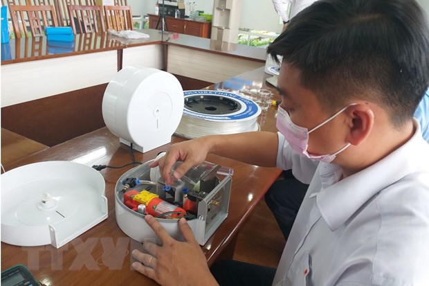 Đoàn viên, thanh niên Dofico chế tạo thiết bị rửa tay tự động chống COVID-19. (Ảnh: Lê Xuân/TTXVN)