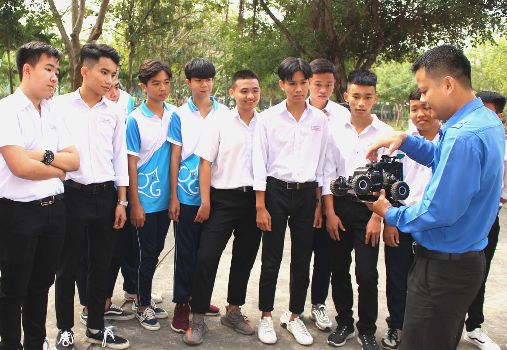 Anh Phạm Lê Giang Dũng hướng dẫn các thành viên trong Câu lạc bộ Thanh niên tình nguyện của trường những kỹ năng cần thiết chuẩn bị cho các cuộc thi thiết kế xe mô hình điều khiển từ xa trong huyện