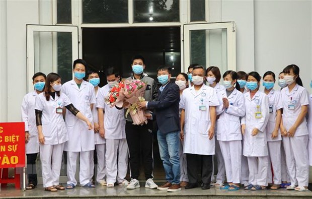 Giám đốc Trung tâm kiểm soát bệnh tật tỉnh Ninh Bình chúc mừng bệnh nhân được xuất viện. (Ảnh: Đức Phương/TTXVN)
