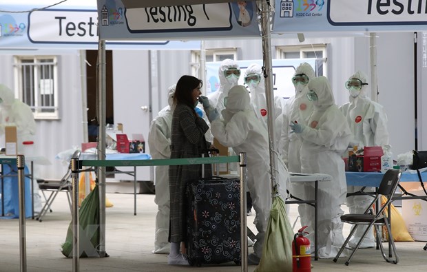 Nhân viên y tế lấy mẫu bệnh phẩm xét nghiệm COVID-19 đối với hành khách đến từ châu Âu tại sân bay quốc tế Incheon, phía tây thủ đô Seoul, Hàn Quốc, ngày 26/3/2020. (Nguồn: Yonhap/ TTXVN)