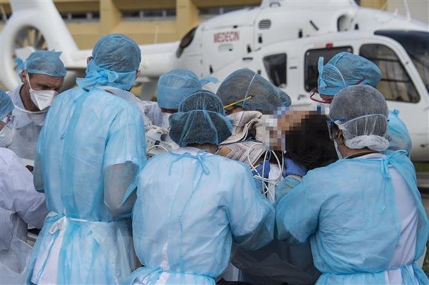 Nhân viên y tế chuyển bệnh nhân nhiễm COVID-19 tại bệnh viện ở Mulhouse, miền Đông Pháp, ngày 22/3/2020. (Ảnh: AFP/TTXVN)