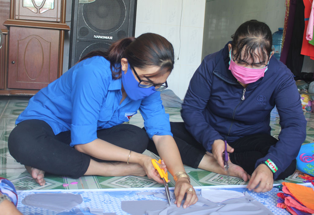 Chị Lương Thị Mai Trinh (bìa trái) cùng đoàn viên thanh niên may khẩu trang vải tặng người dân, góp phần phòng, chống Covid-19
