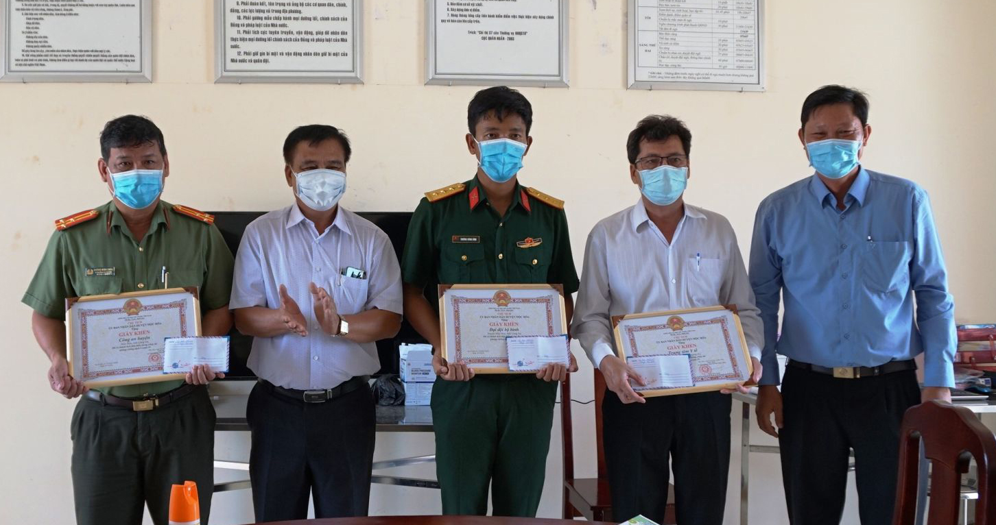 Bí thư Huyện ủy Mộc Hóa - Dương Văn Tuấn (áo trắng) tặng giấy khen cho đại diện các tập thể