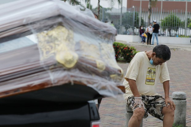 Người thân của nạn nhân mắc COVID-19 khóc bên cạnh một chiếc quan tài ở Guayaquil. (Nguồn: Getty Images)